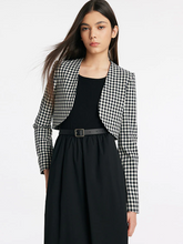 a lady in black and white check crop jacket with black top and black pants